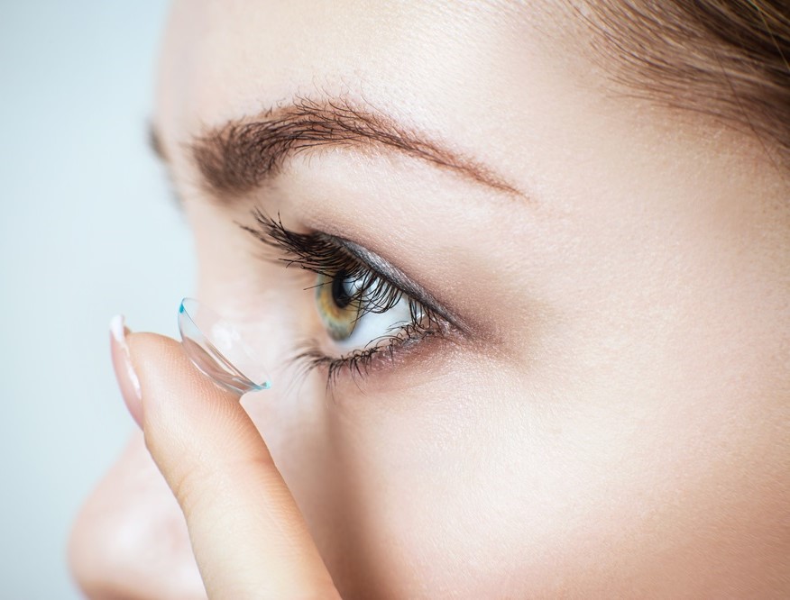 Close-up shot of young woman wearing contact lens.