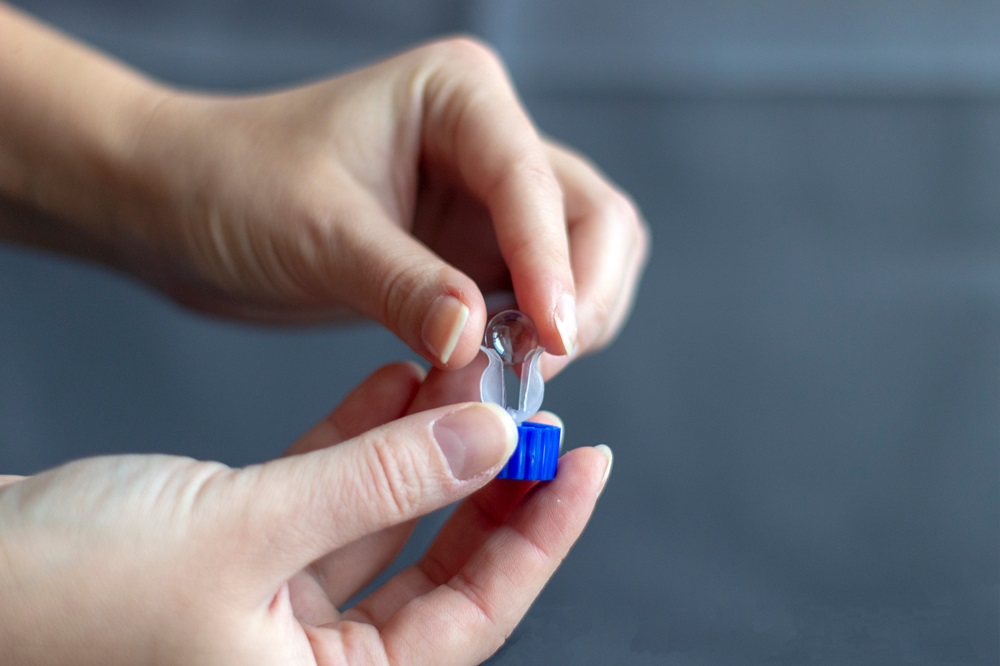 Hands putting orthokeratology lens into container