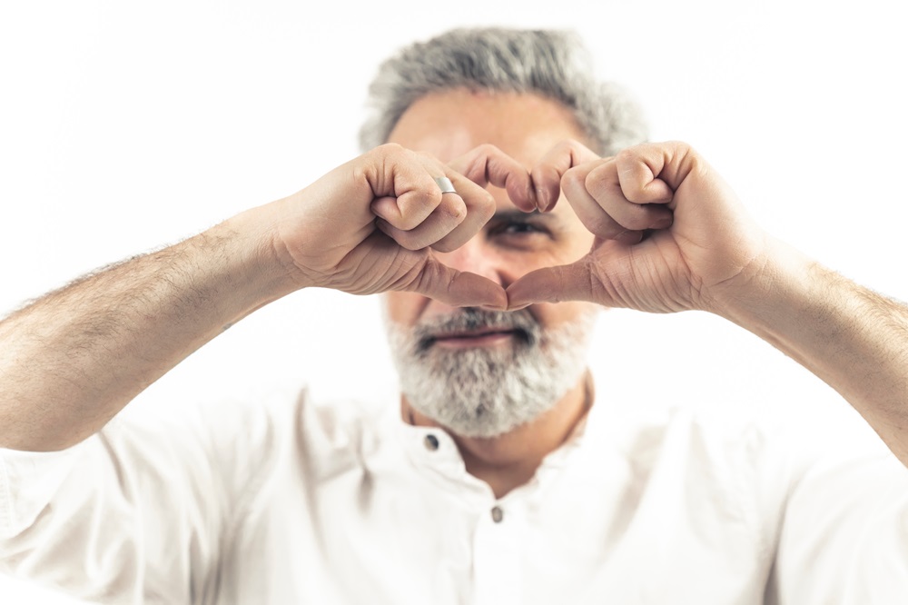 man making heart shape with his hands